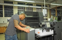 Luis Gremli nimmt die Offsetdruckmaschiene in Betrieb